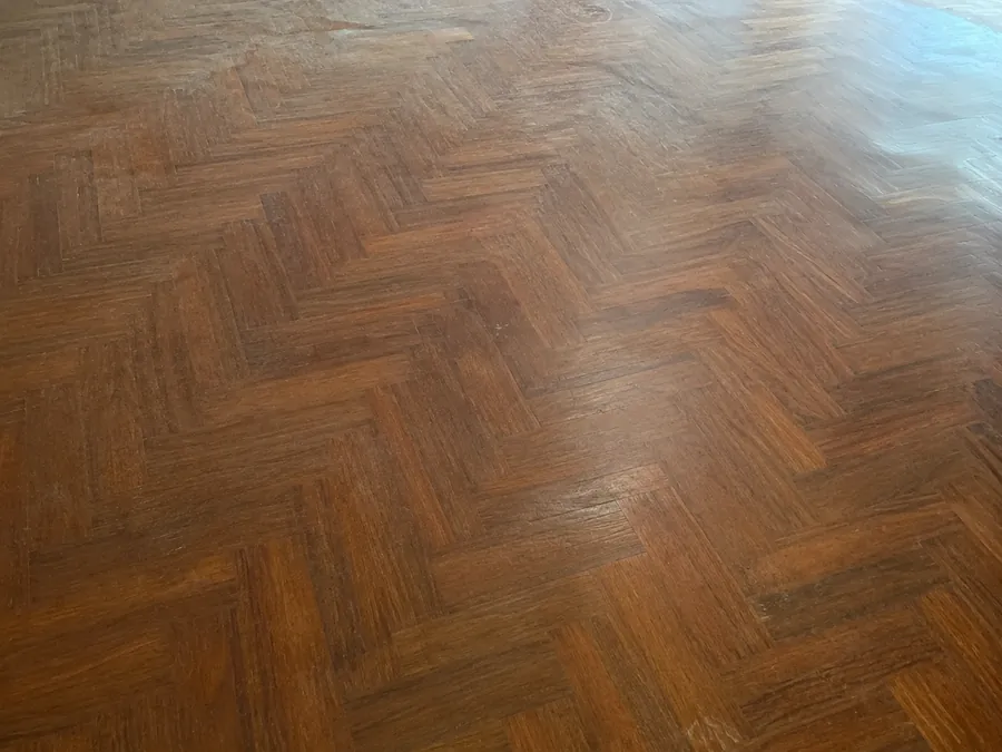 Suelo de parquet en espiga desgastado antes de acuchillar y barnizar